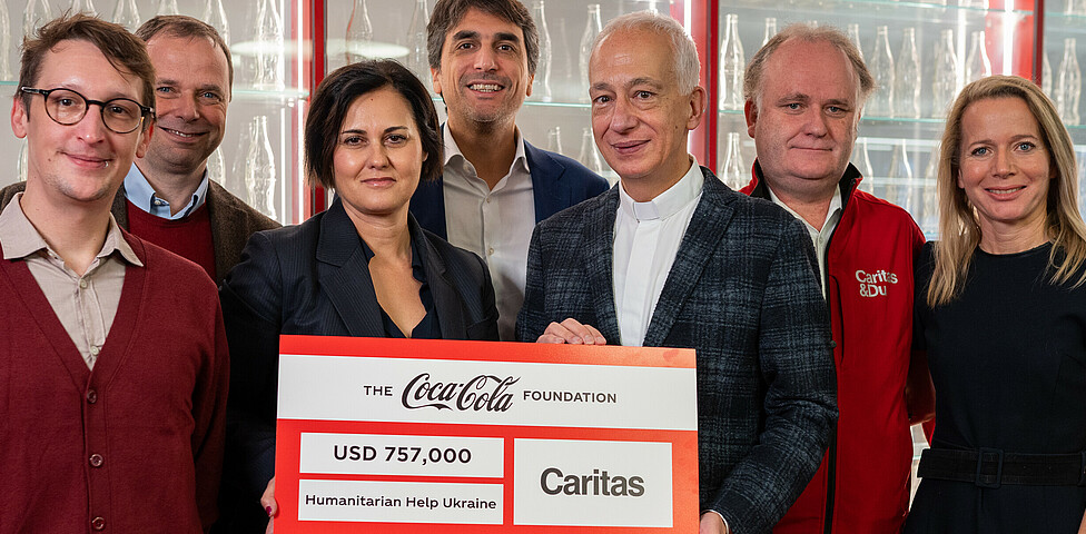 Vertreter*innen von Coca-Cola und Caritas Österreich bei der Scheckübergabe