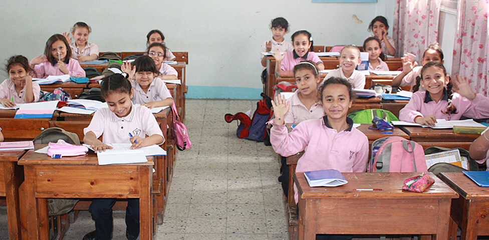 Klassenzimmer mit einer Gruppe Mädchen, die in ihren Schulbänken sitzen.