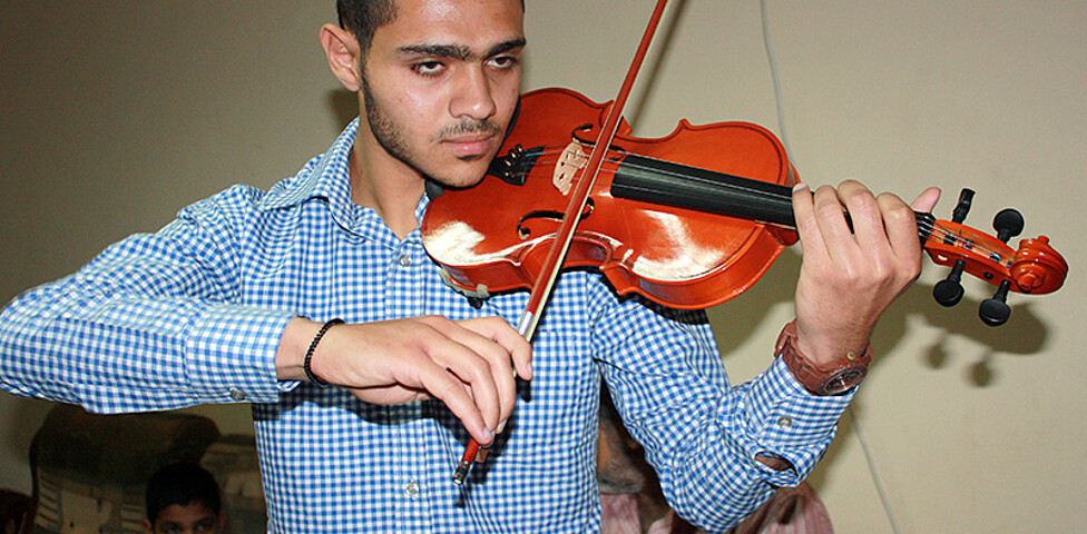 Ein Jugendlicher beim Violine-Spielen im Betreuten Wohnen für Straßenkinder in Alexandria.
