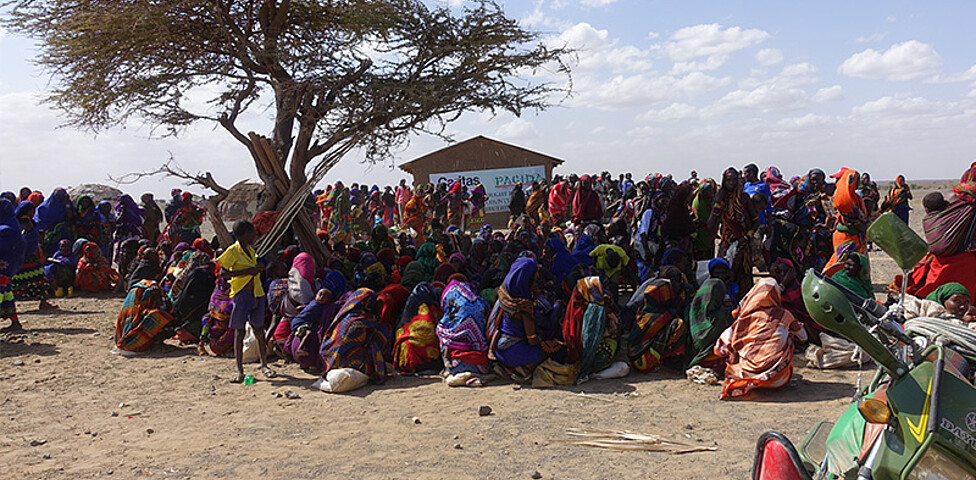 Eine große Gruppe von Menschen in Kenia wartet auf eine Lebensmittelverteilung.