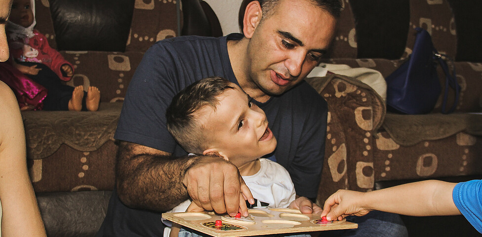 Doni ein Junge mit Behinderungen übt mit seinem Betreuer des Frühförderungszentrums im Kosovo mit Holztieren.