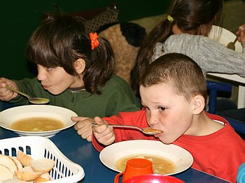Ein Bub und ein Mädchen essen Suppe in der Kindertagesstätte in Nadrag.