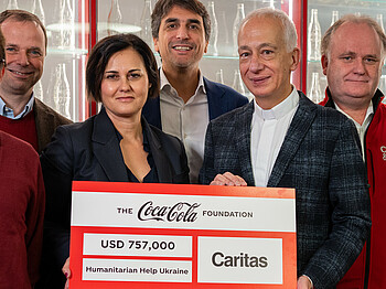 Vertreter*innen von Coca-Cola und Caritas Österreich bei der Scheckübergabe