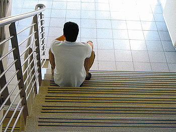 Asylwerber sitzt auf Treppen