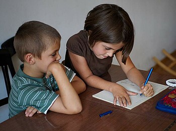 Zwei Kinder im Volkschulalter bei Hausübungen