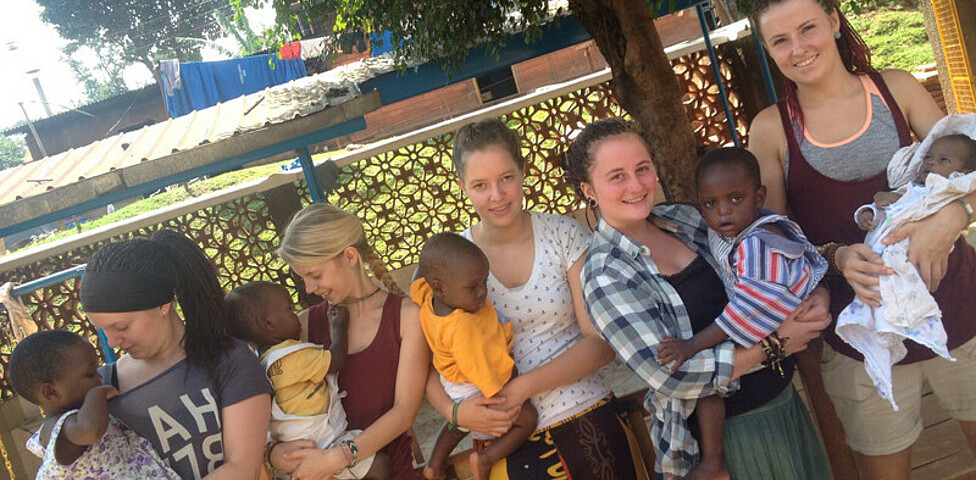 Vier junge Frauen mit jeweils einem kleinen Kind am Arm.