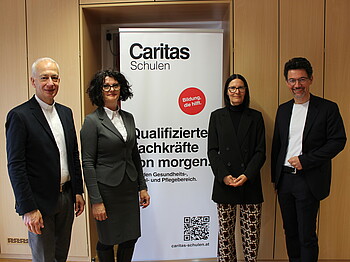(v.l.n.r.) Michael Landau, Manuela Kröll, Birgit Poier und Ernst Sandrießer stehen vor einem Caritas-Roll Up.