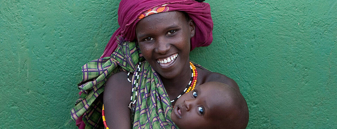 Frau mit Getreide und Baby in Kenia